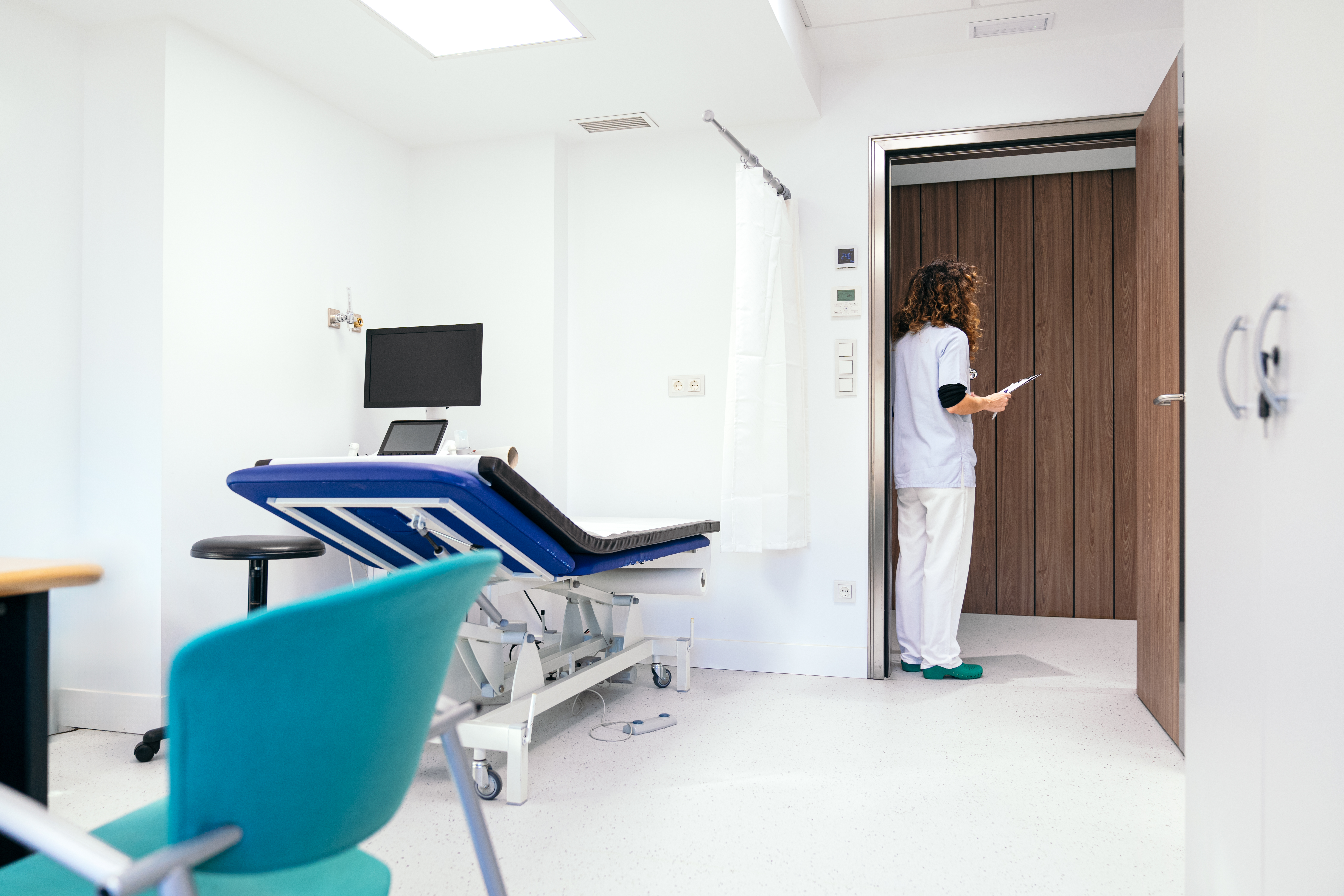 nurse in clinic doorway, calling a patient in